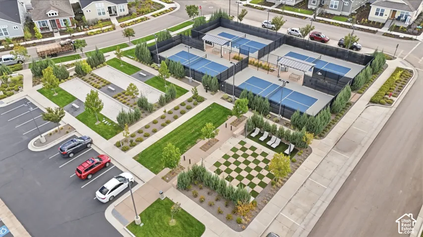 Multiple pickleball courts with black fencing, a dedicated parking area, and a bocce ball court