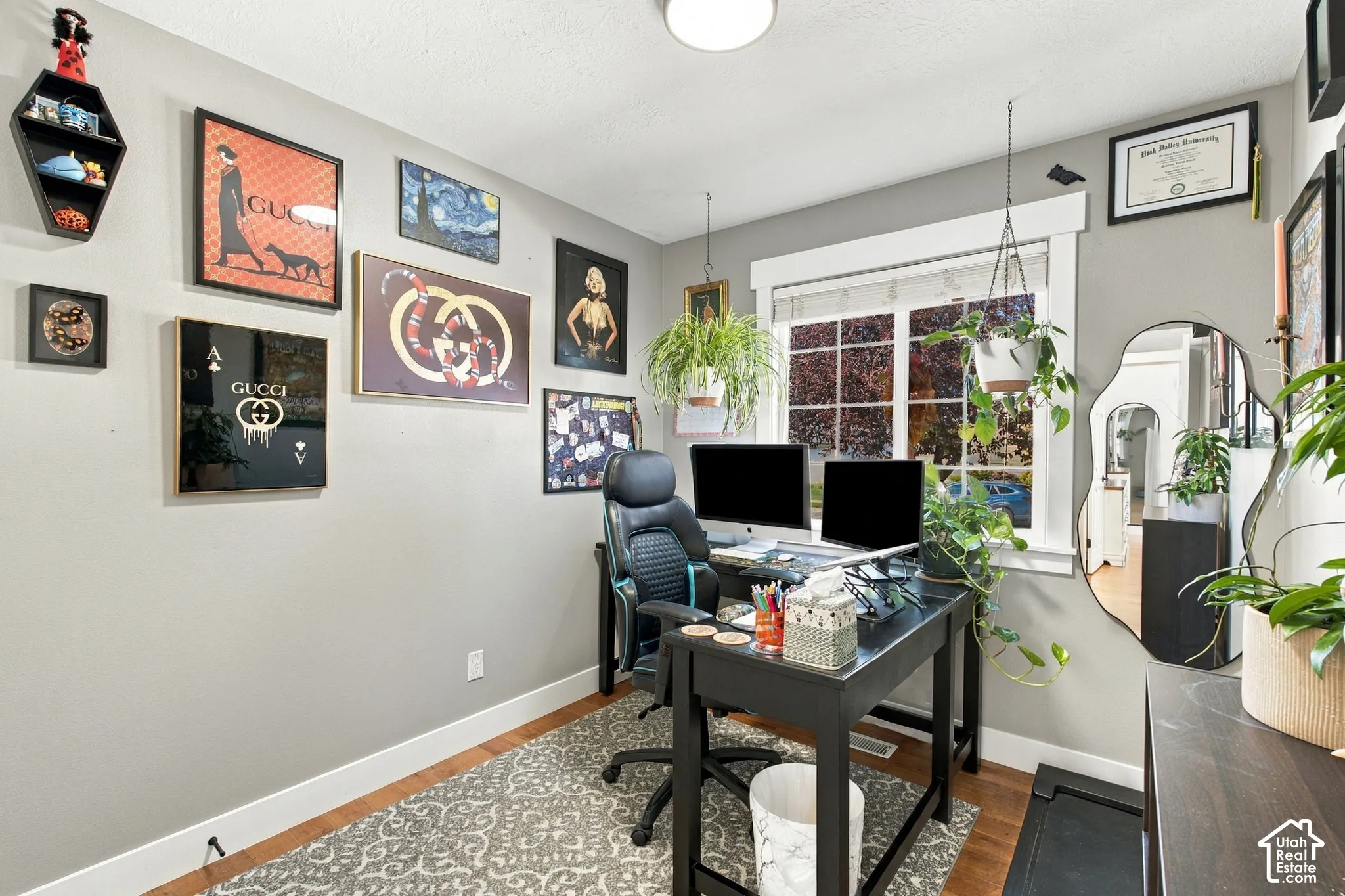 Bedroom currently used as an office with hardwood flooring neutral wall tones