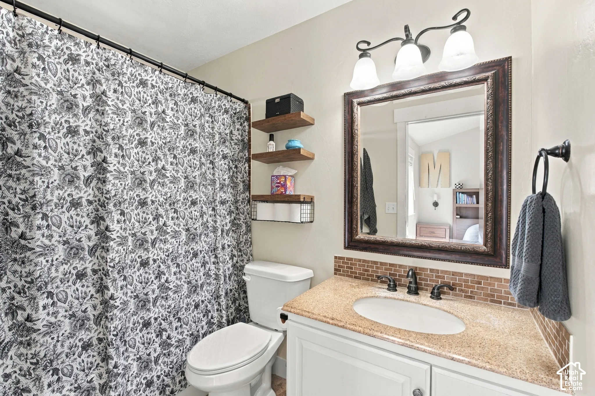 Primary bathroom Vanity with a speckled countertop, undermount sink, and bronze-finish faucet