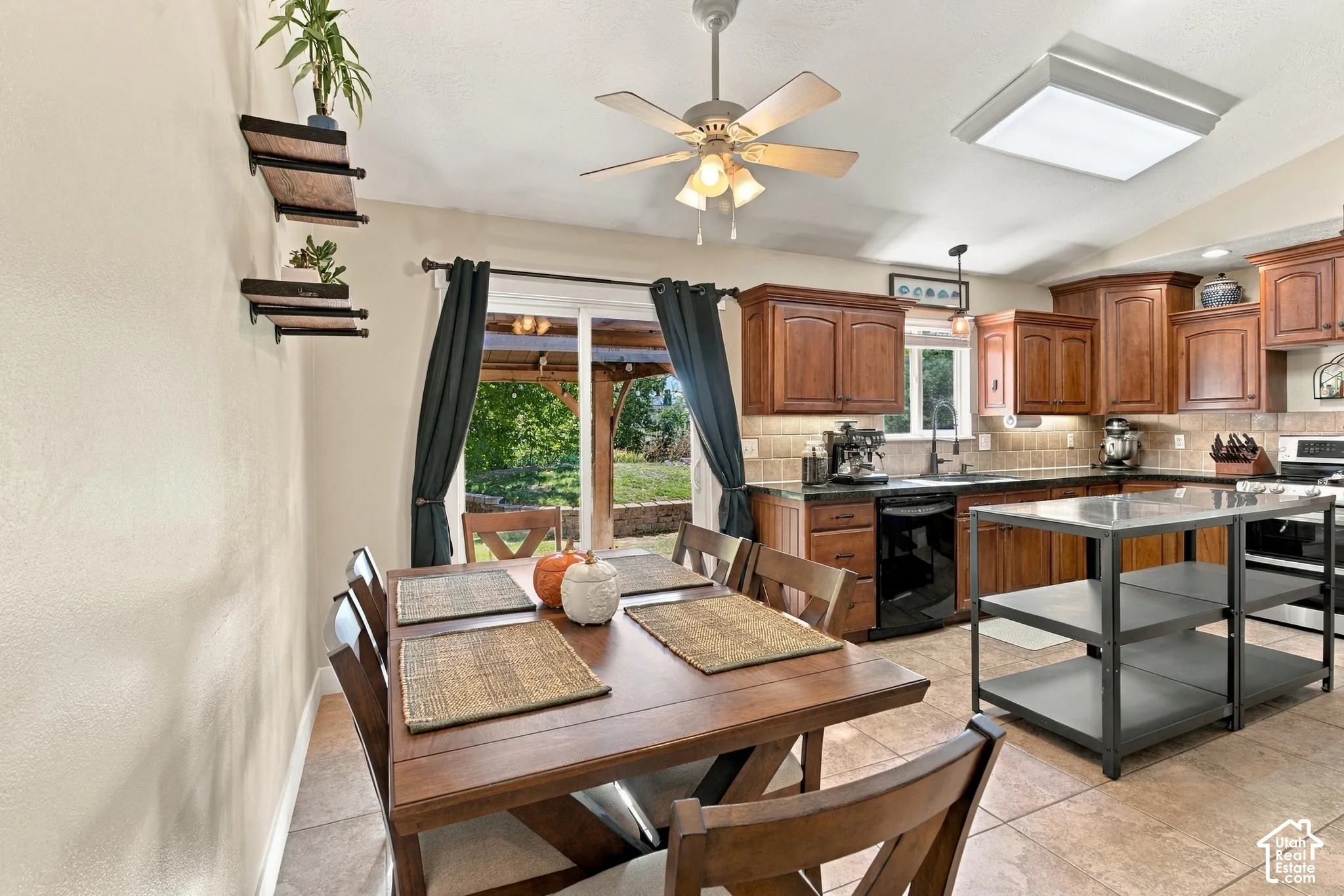 Kitchen with wood-finish cabinetry, dark countertops, and a tiled backsplash