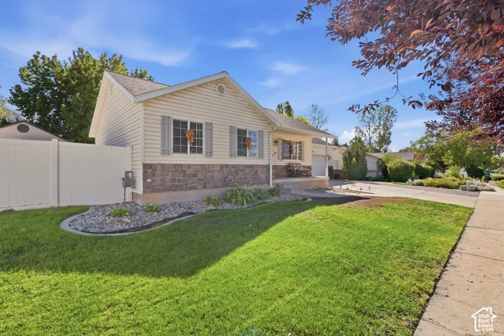 Siding exterior with decorative shutters, stone accent facade, and a fenced yard