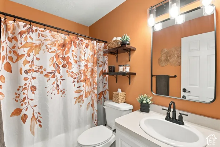 Bathroom featuring a vanity with a white countertop, oval undermount sink, and a black faucet