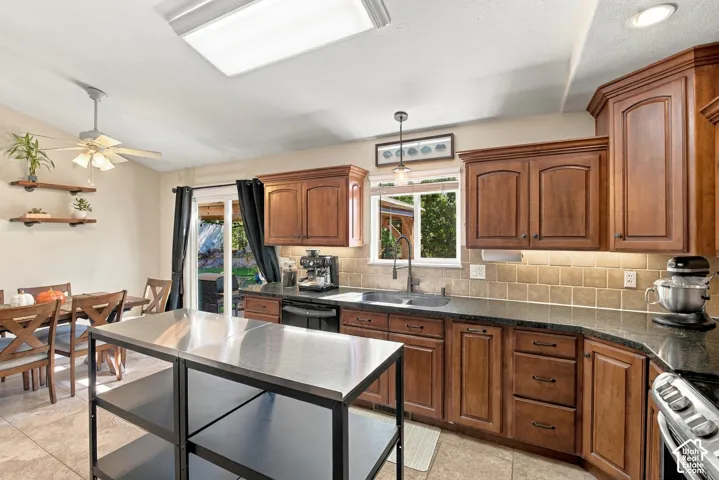 Kitchen featuring wood cabinetry, stone countertops, and a tile backsplash