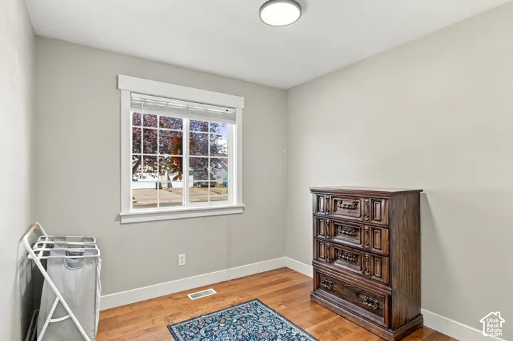 Hardwood flooring, painted walls, window with gridded panes, ceiling-mounted light fixture, and white trim