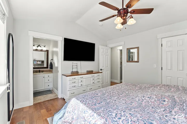 Primary bedroom vaulted ceiling with a ceiling fan, recessed lighting, and wood-finish flooring