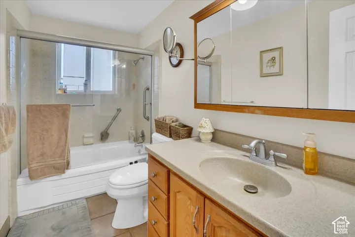 Tile flooring with a single vanity featuring a built-in sink and wood-finish cabinetry