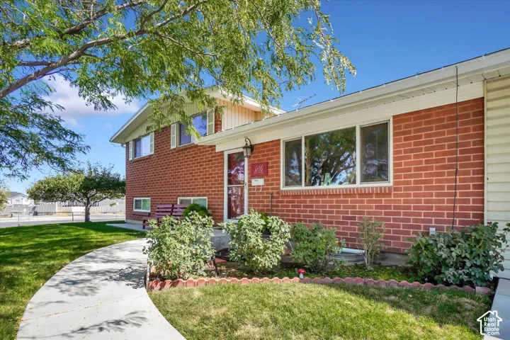 Red brick exterior with white siding accents and a curved concrete walkway