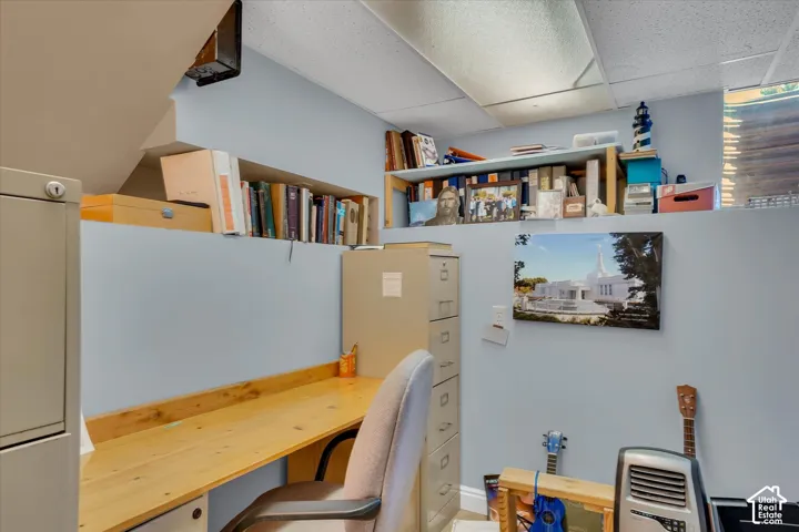 Built-in desk surface with wood finish, recessed shelving, and a drop-panel ceiling