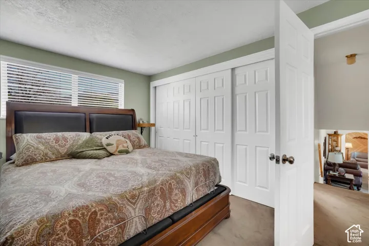 Window with horizontal blinds, built-in sliding closet doors, and recessed lighting