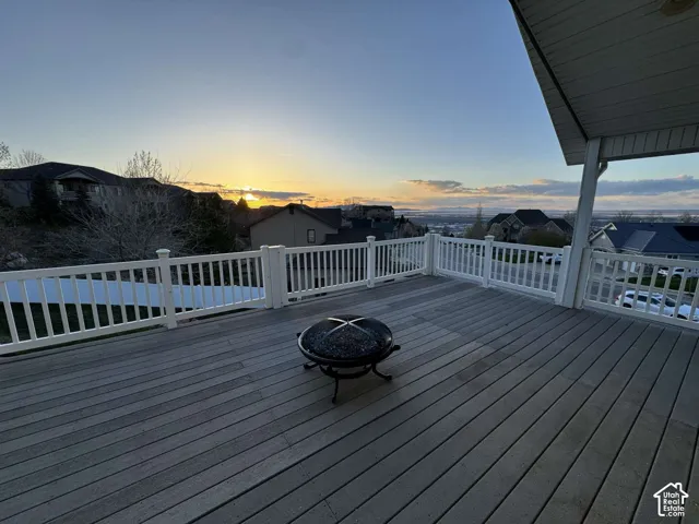 Spacious outdoor deck with composite decking, white railing, covered patio section, and a panoramic skyline
