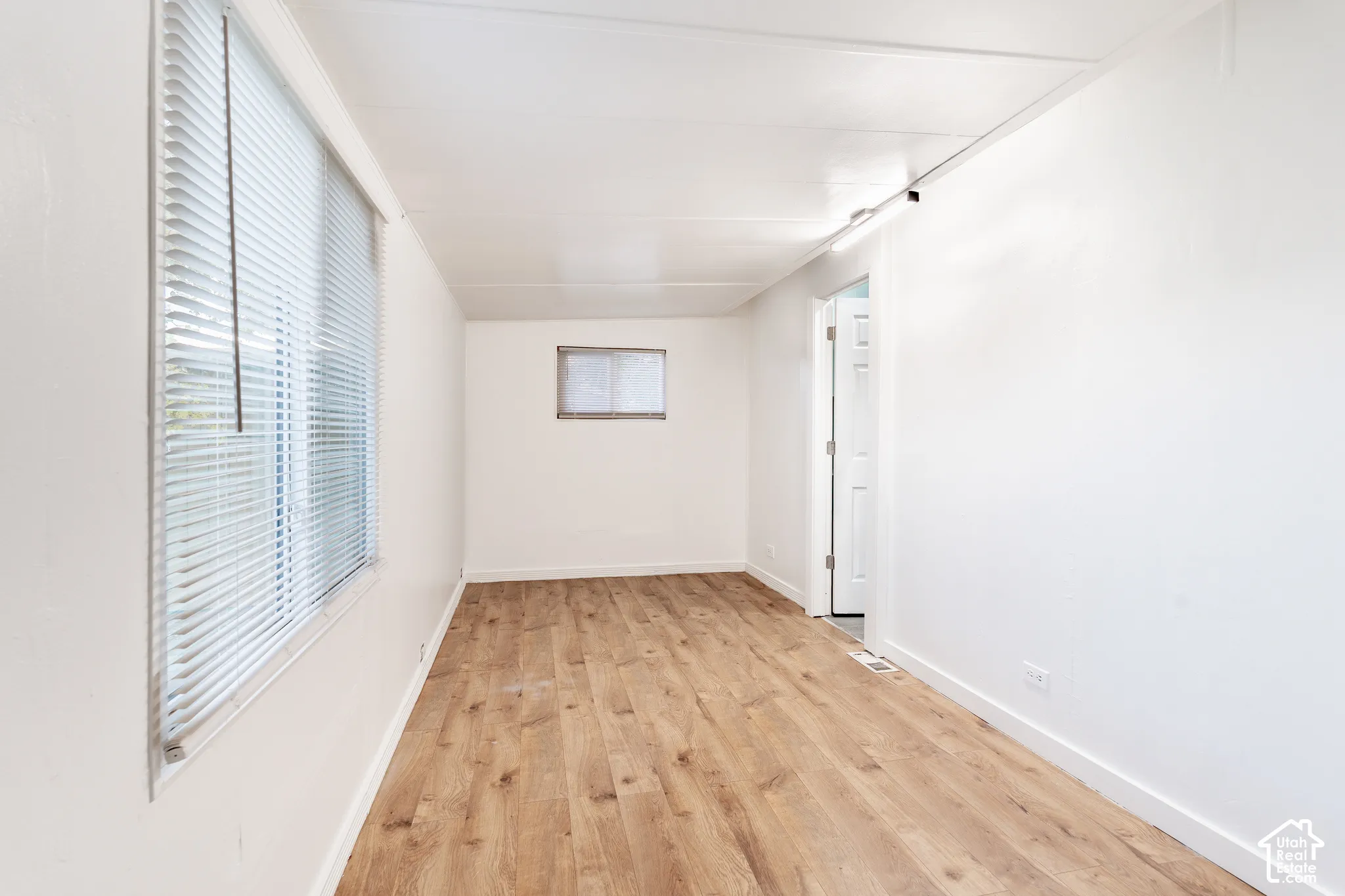 Wood-finish flooring, white walls, and a white ceiling create a bright interior