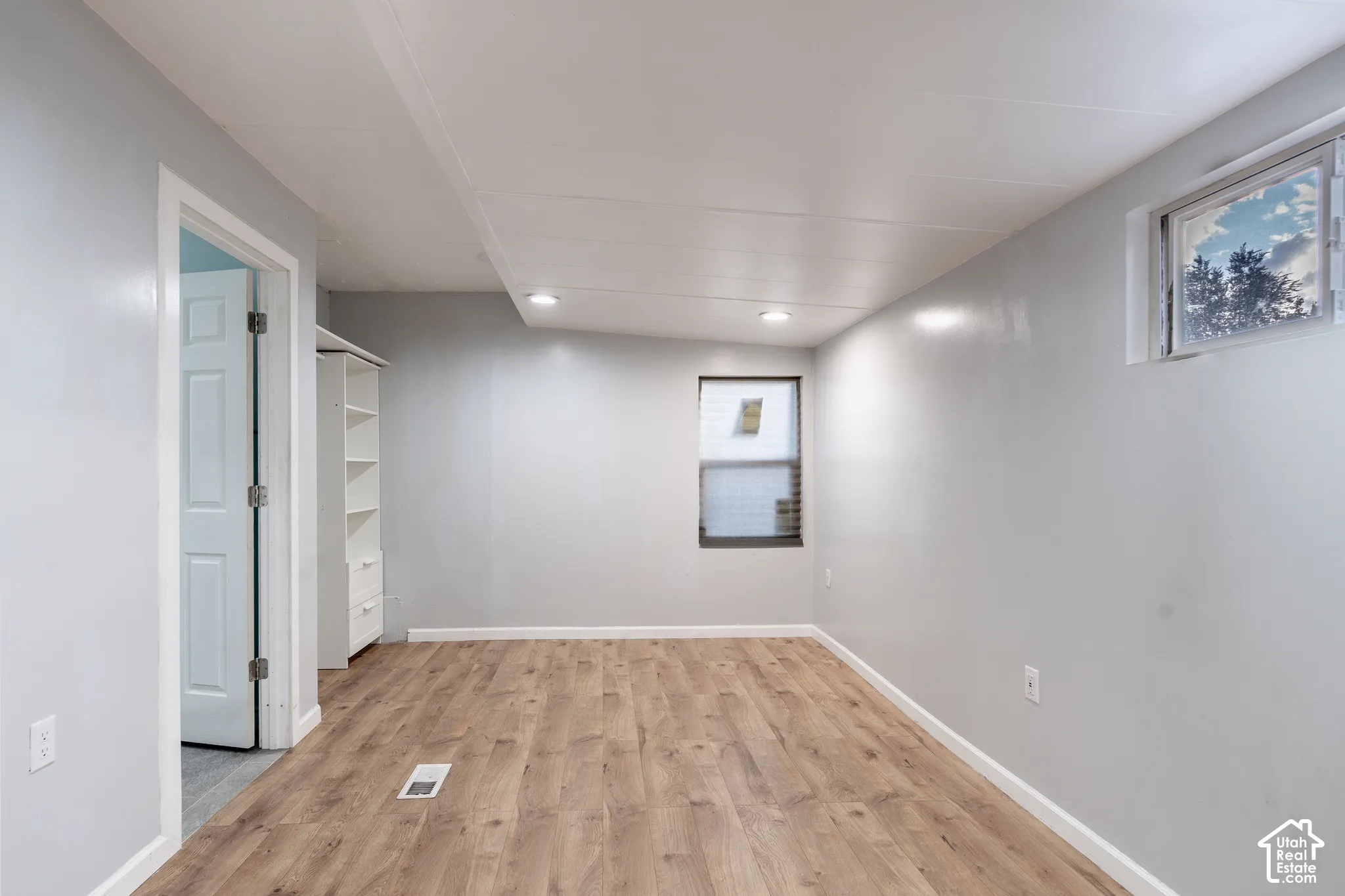 Wood-finish flooring, recessed lighting, and light gray wall color