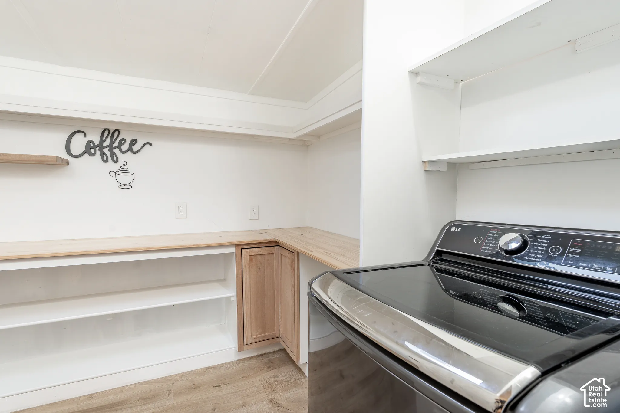 White built-in shelving, wood-finish countertops, wood-finish flooring, and light wood cabinetry