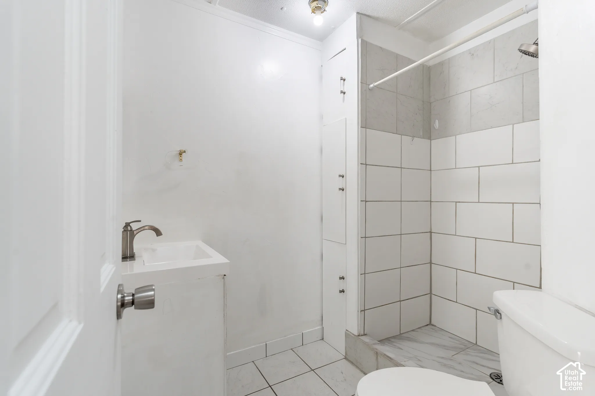 White subway tile shower surround with a built-in shower niche and a tiled shower pan