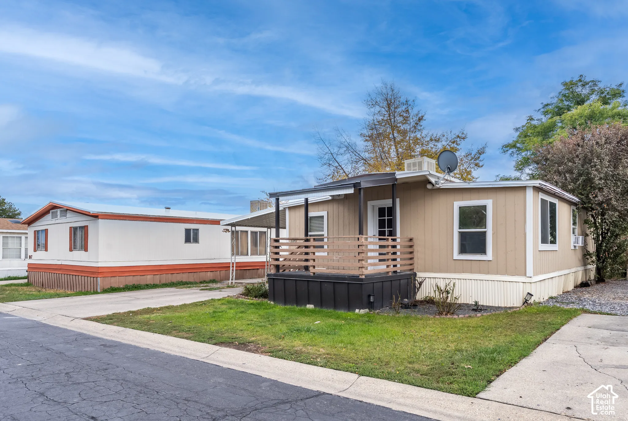 Carport providing covered parking, exterior entry stairs, front porch with wooden railing, and established landscaping