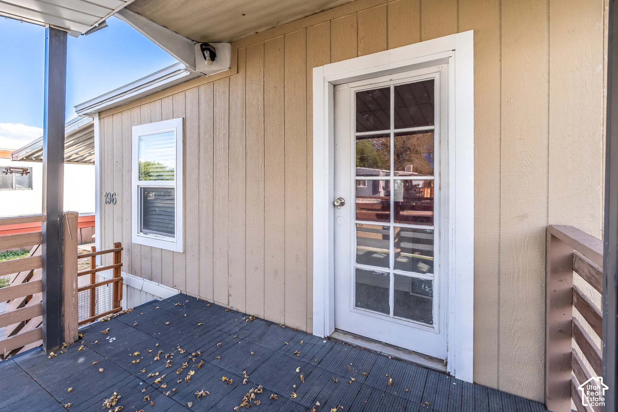 Entry door with glass paneling, durable exterior siding, and a window with blinds