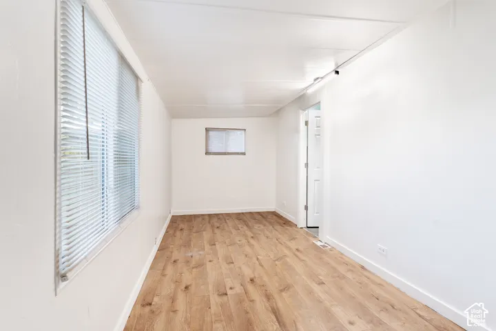 Wood-finish flooring, white walls, and a white ceiling create a bright interior