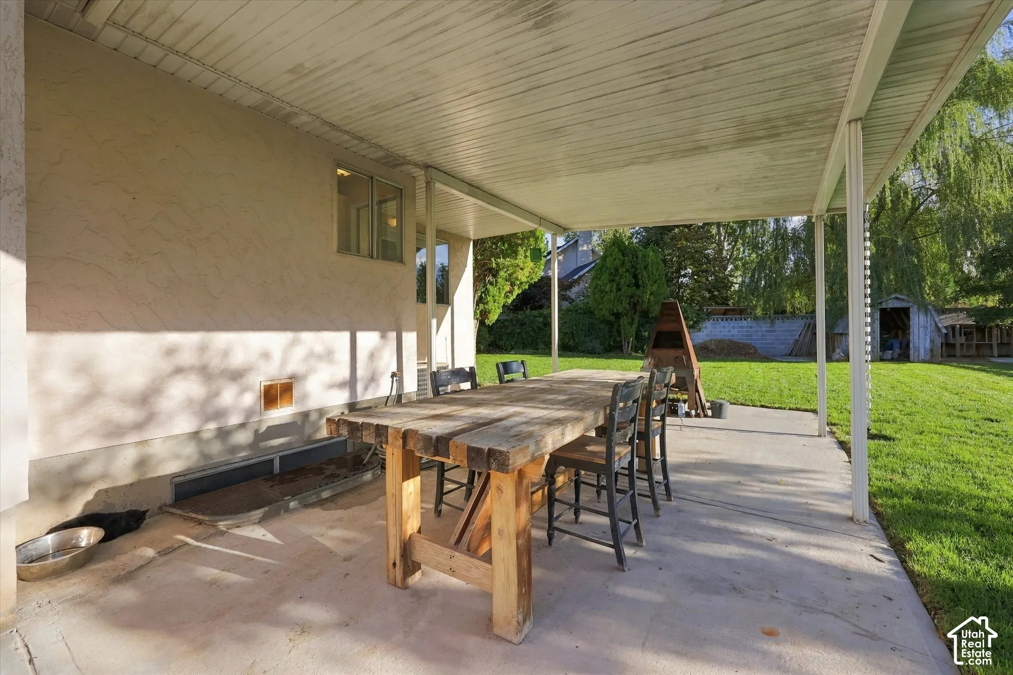 Expansive covered patio with concrete flooring and stucco exterior wall