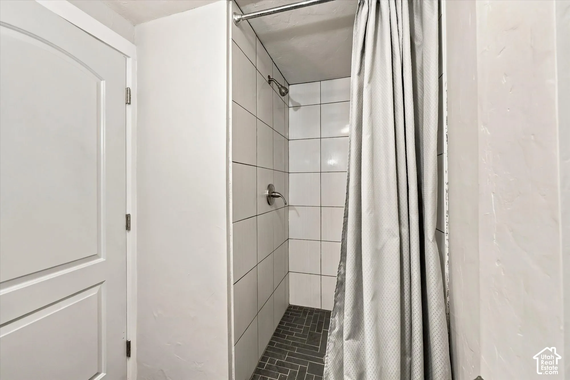 Tiled shower with a dark gray herringbone floor