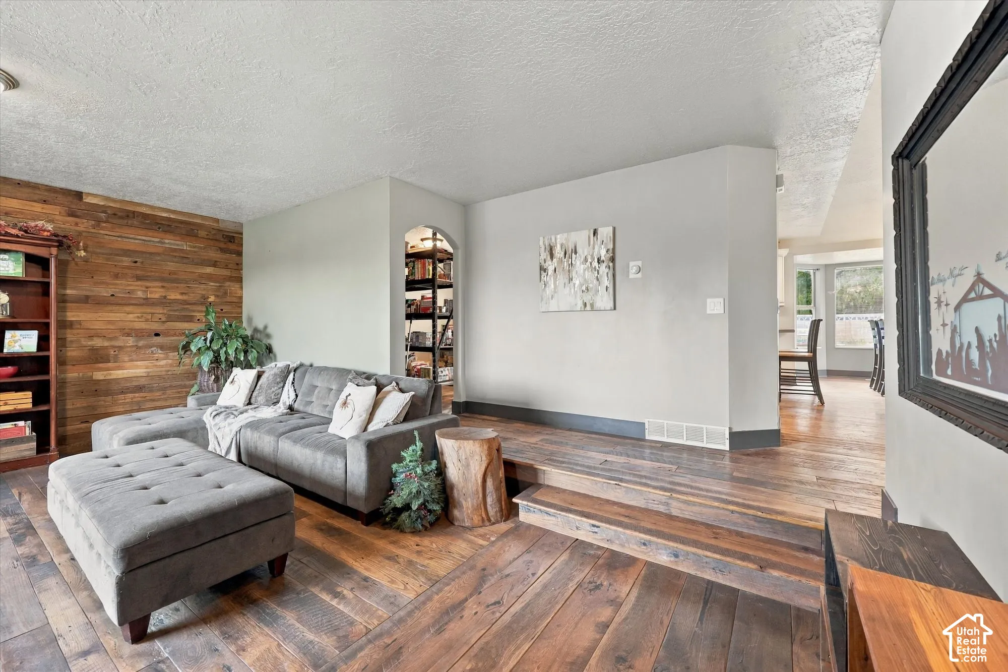 Accent wood-paneled wall, hardwood flooring.