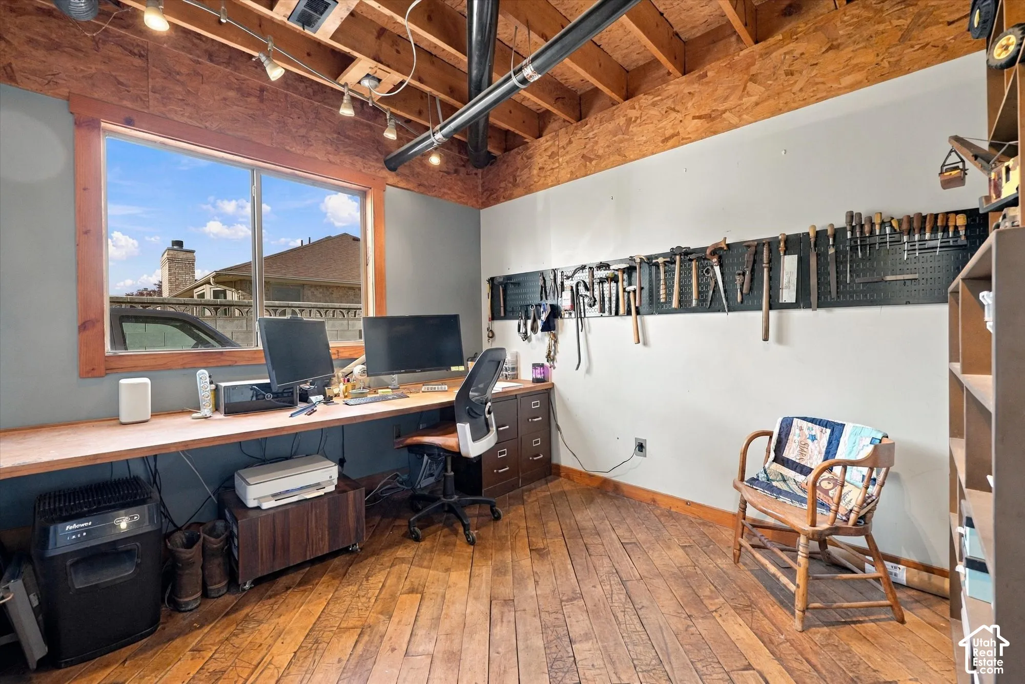 Exposed wood ceiling with track lighting, hardwood flooring, built-in desk, and a window