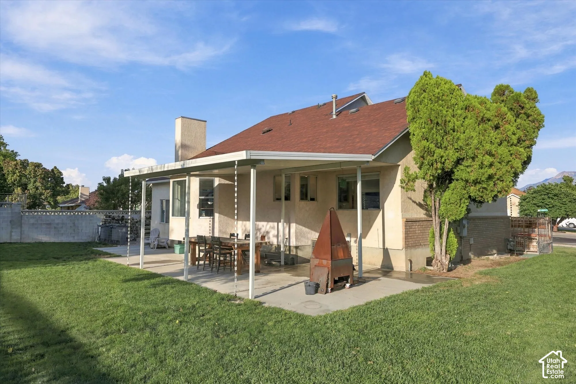 Expansive lawn with a concrete patio featuring a covered outdoor living area