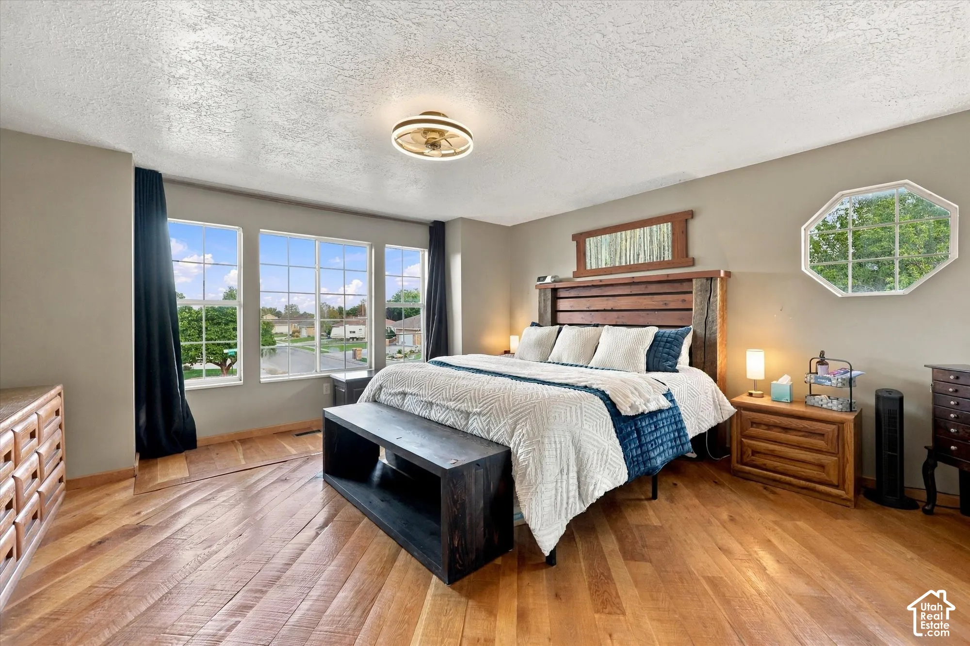 Hardwood flooring, multiple paneled windows with beautiful mountain views, octagonal window, and a wood paneled headboard