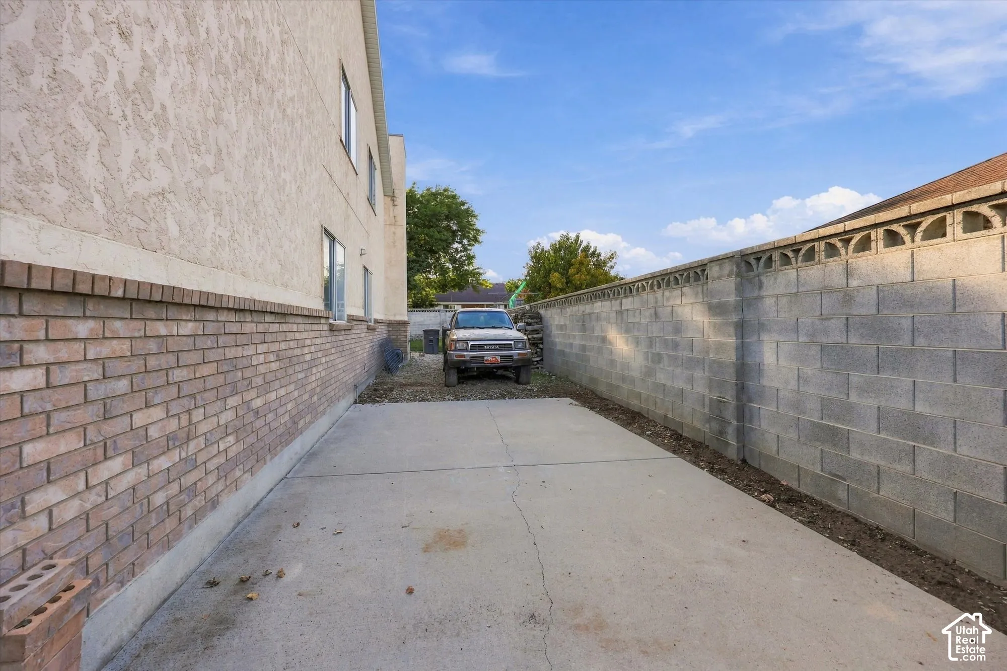 Concrete drive, brick and stucco exterior, block wall with decorative elements
