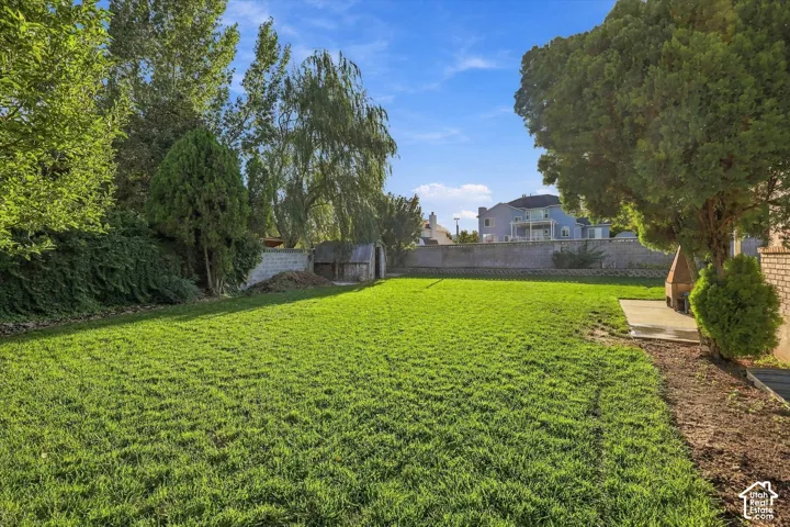 Expansive lawn area with mature trees and perimeter landscaping
