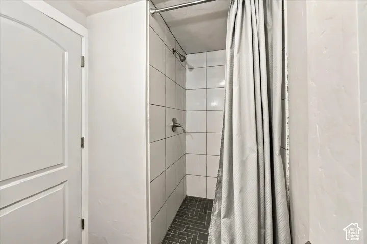 Tiled shower with a dark gray herringbone floor