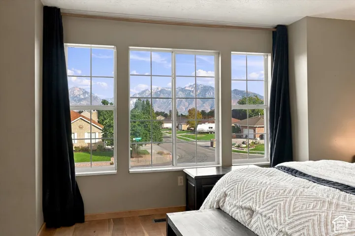 Triple picture windows with grids, light wood-finish flooring.