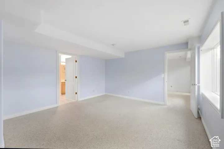 Mother in law primary bedroom with Recessed lighting, light-toned carpeting, ample natural light, light blue wall finishes, and white trim