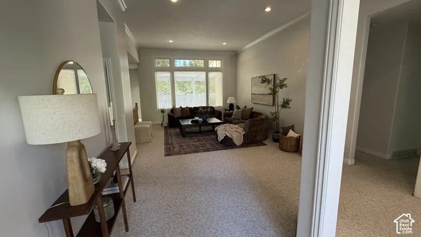 Spacious room featuring multiple large windows, recessed ceiling lighting, and crown molding