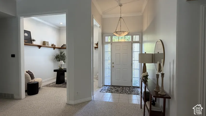 Entryway featuring a paneled door with sidelights, transom window, and a chandelier