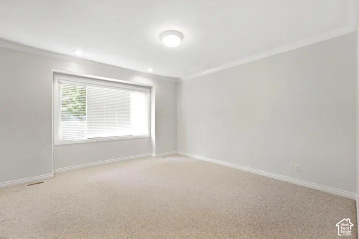 Carpeted flooring, recessed lighting, crown molding, and a window with blinds