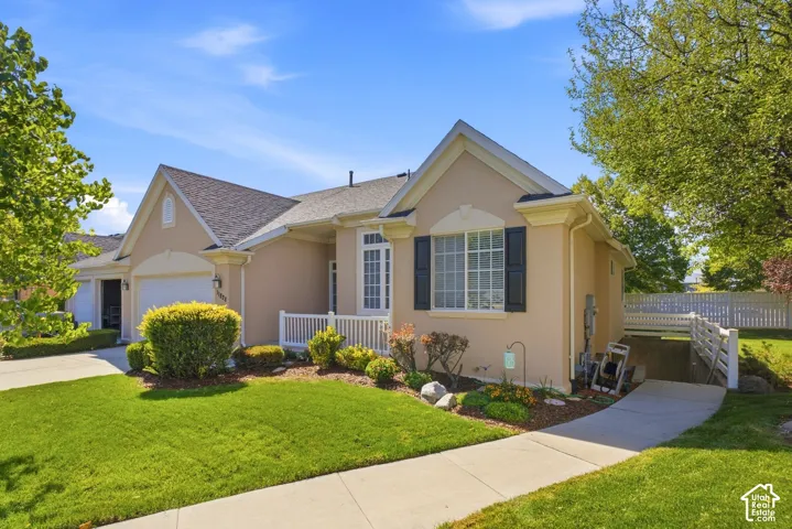 Stucco exterior with a pitched roof, front entry garage, and a gated side yard