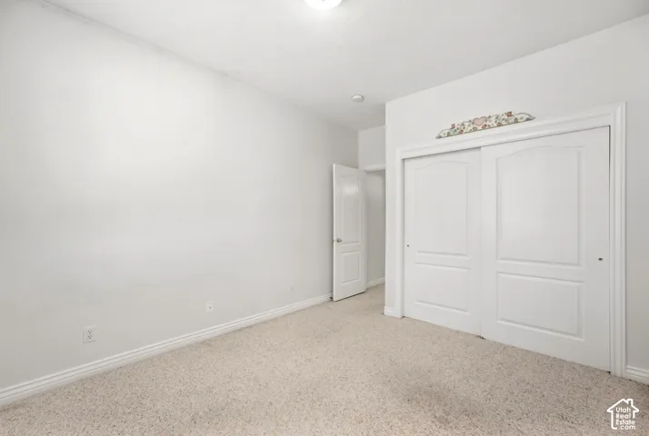 Wall-to-wall carpeting, white baseboards, white walls, and a recessed ceiling light