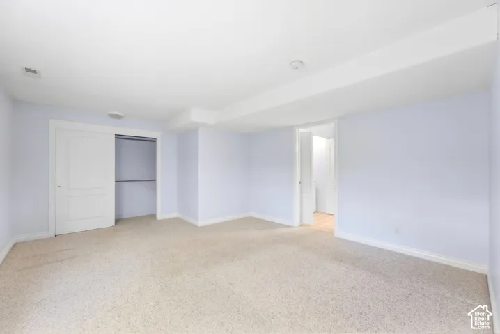 Soft neutral carpeting, light-toned walls, and a sliding door closet