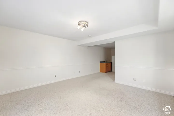 Spacious room with light-colored carpeting and white walls