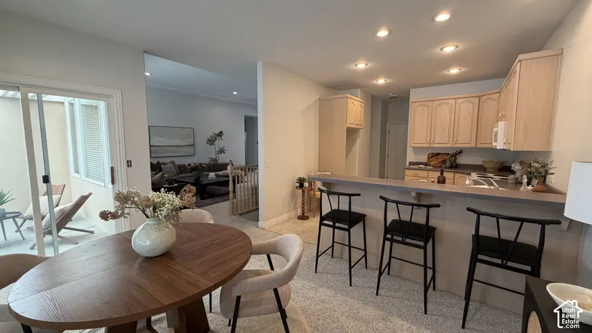 Kitchen featuring wood-finish cabinetry, a breakfast bar, and recessed lighting