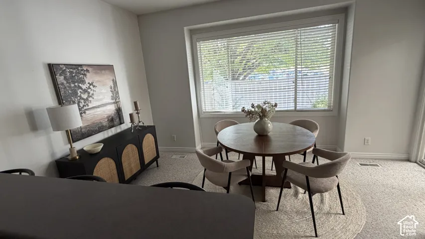 Carpeted room with a large window and a sliding glass door