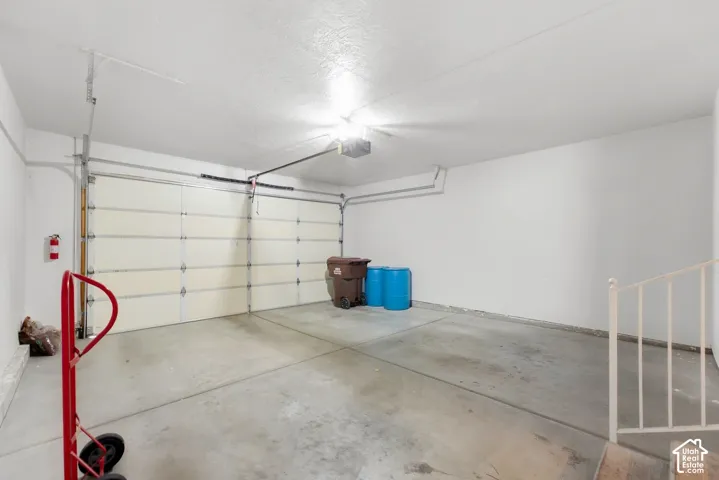 Concrete flooring and white painted walls with a segmented garage door