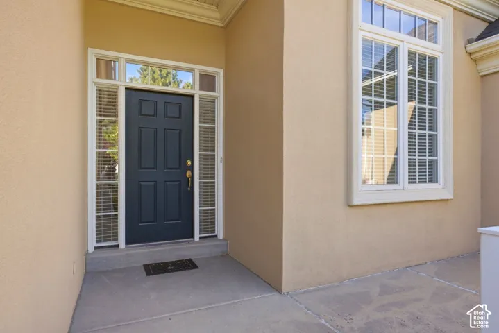 Stucco exterior with a paneled dark entry door, transom windows, and white trim accents