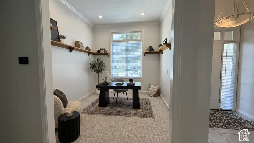 Recessed lighting illumination, wall-mounted shelving, window with blinds, crown molding, and a front entry door with transom window
