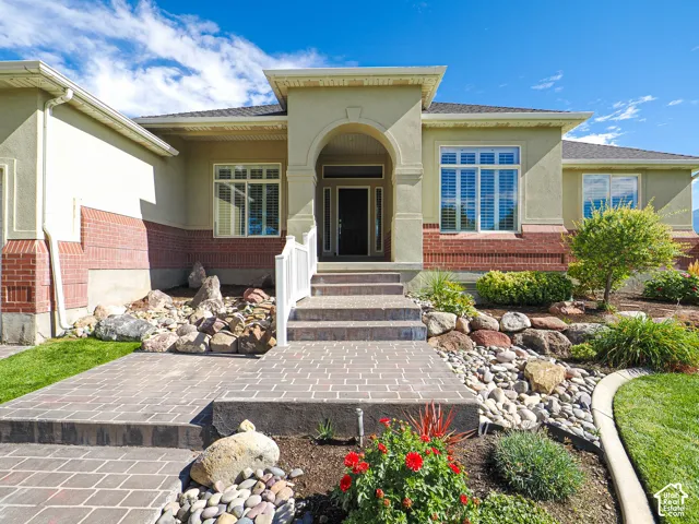 Stucco and brick exterior with a prominent arched entry