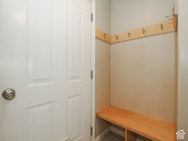 Recessed entryway bench with a wood finish, complemented by a coat rack featuring multiple hooks
