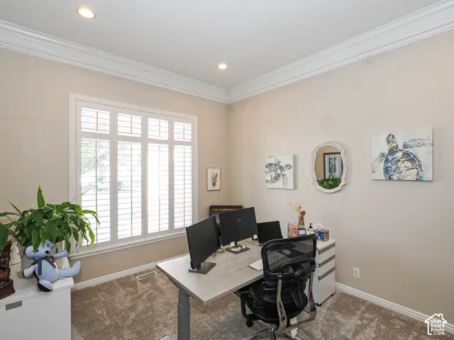 Recessed lighting, crown molding, plantation shutters, and light-toned carpeting