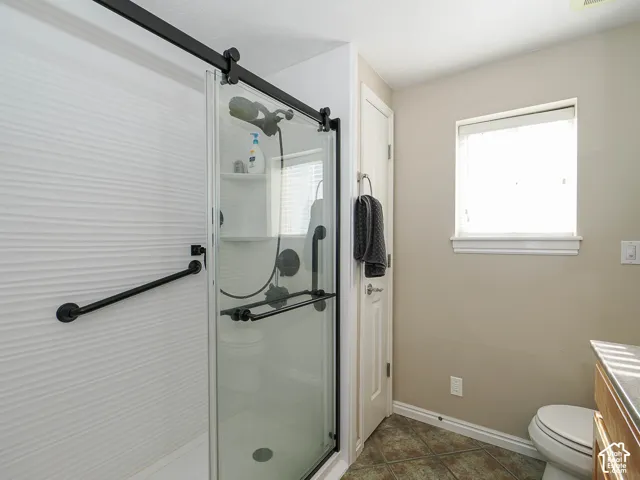 Walk-in shower with a barn door style glass enclosure and matte black hardware