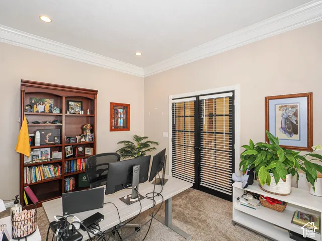 Recessed lighting, crown molding, and neutral wall tones complement the durable carpet flooring