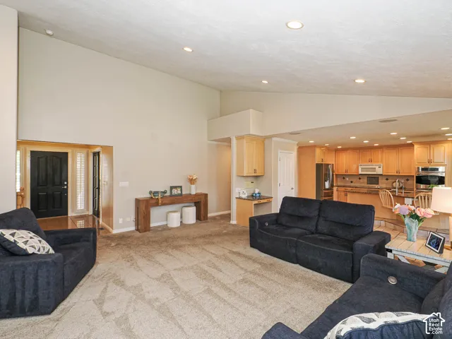 Recessed lighting, wood-finish flooring, light-toned walls, built-in cabinetry, and a kitchen with stainless steel appliances